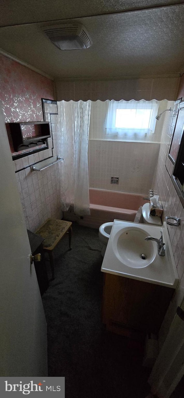 full bathroom with shower / tub combo, vanity, tasteful backsplash, a textured ceiling, and toilet