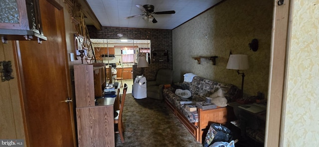 living room featuring ceiling fan, brick wall, and dark carpet