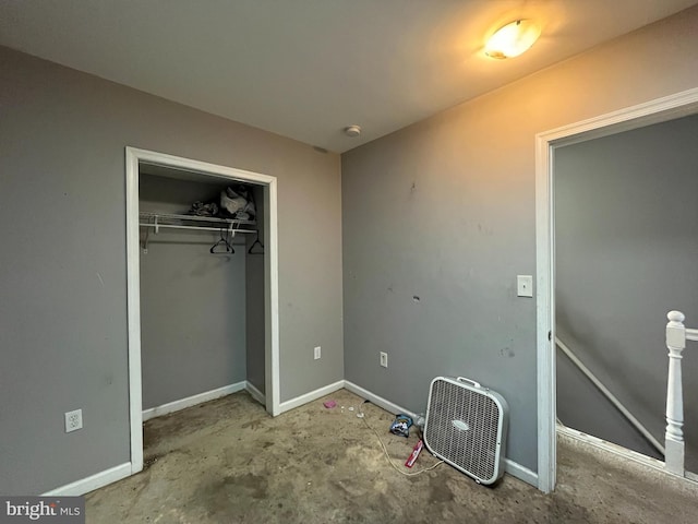 unfurnished bedroom featuring concrete flooring and a closet