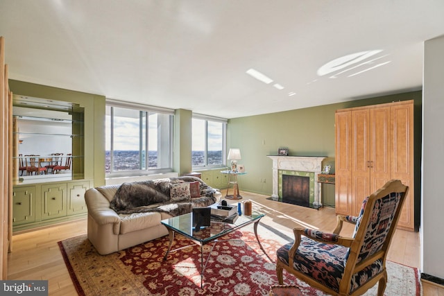 living room featuring a high end fireplace and light wood-type flooring