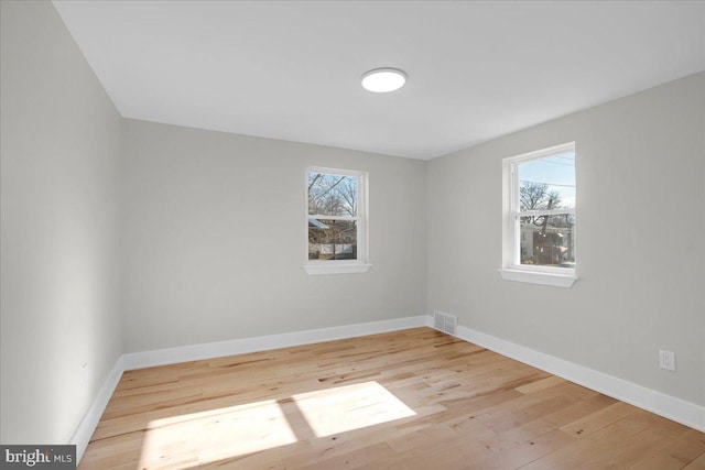 unfurnished room featuring plenty of natural light and light hardwood / wood-style flooring