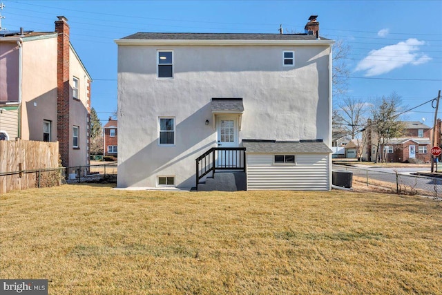 rear view of property with a lawn and central air condition unit