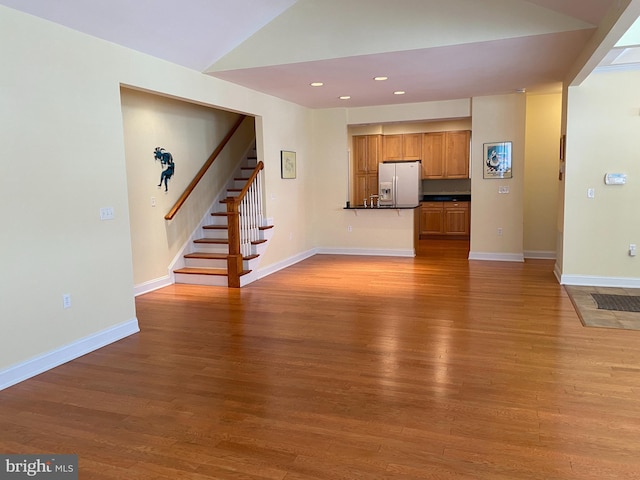 unfurnished living room with vaulted ceiling and hardwood / wood-style floors