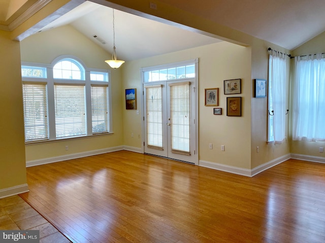 entryway with vaulted ceiling, light hardwood / wood-style floors, and french doors