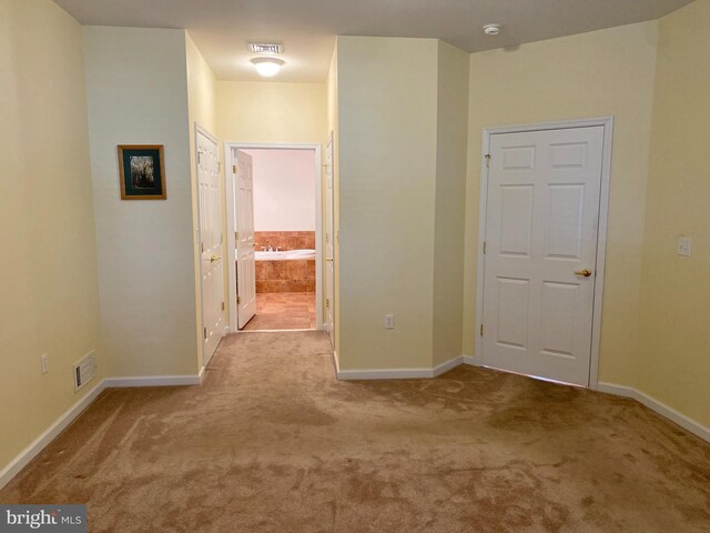 hallway featuring light colored carpet