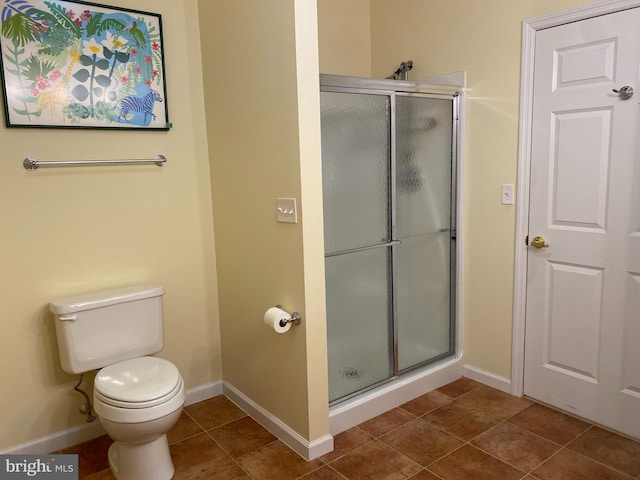 bathroom with a shower with door, tile patterned flooring, and toilet