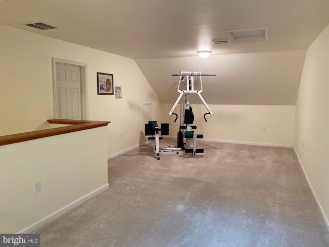 exercise room with lofted ceiling and light colored carpet