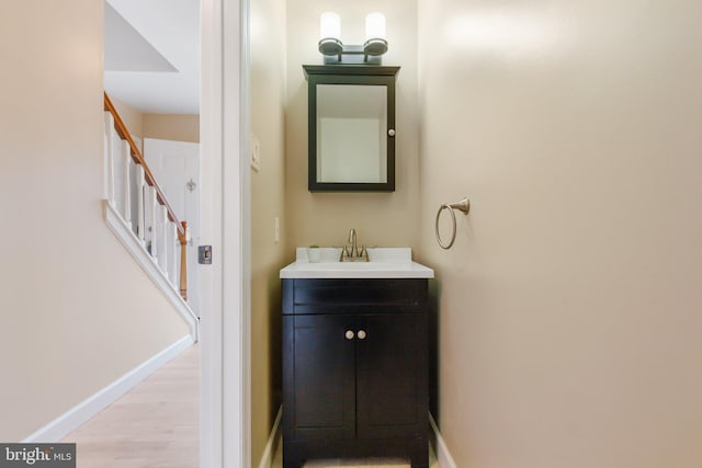 bathroom with vanity, baseboards, and wood finished floors