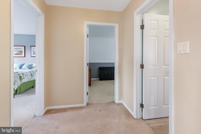 hall featuring carpet flooring and baseboards