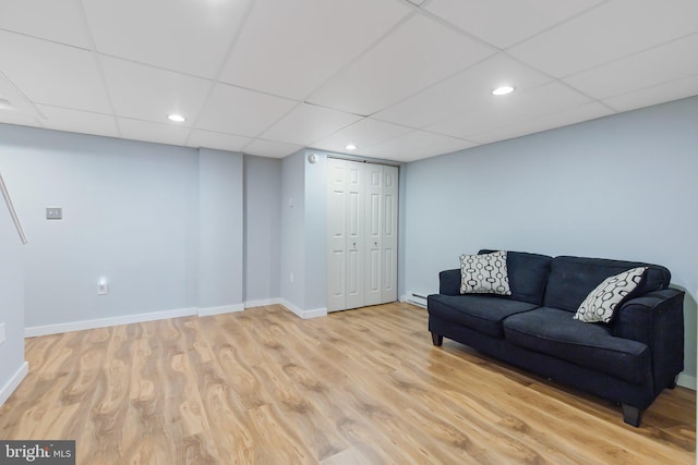 sitting room featuring a drop ceiling, recessed lighting, baseboards, and wood finished floors