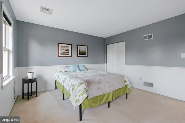 bedroom featuring visible vents and wainscoting