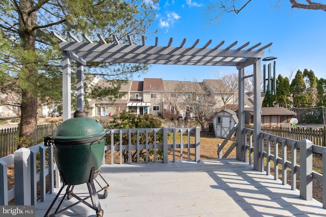 view of patio featuring an outbuilding, fence, a shed, a pergola, and a residential view