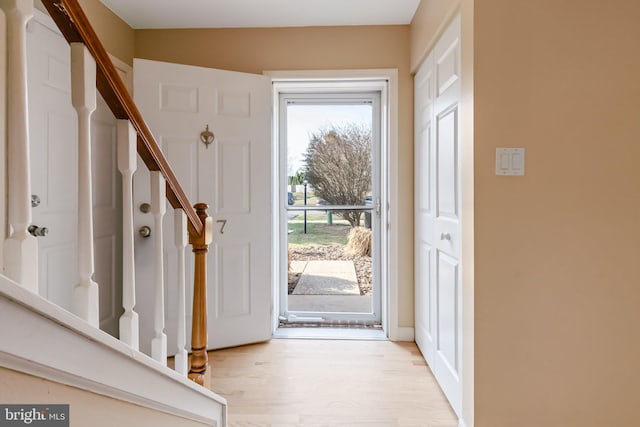 foyer featuring light wood-style flooring and stairs