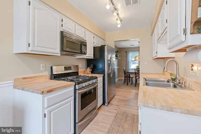 kitchen featuring visible vents, white cabinets, appliances with stainless steel finishes, and a sink