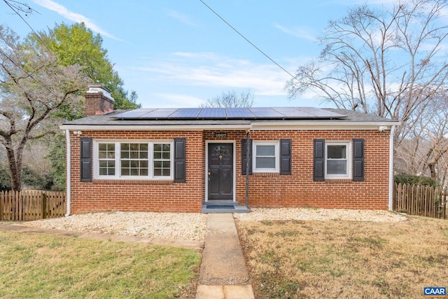 view of front of house featuring a front lawn and solar panels