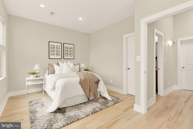 bedroom with light wood-style floors, baseboards, and recessed lighting