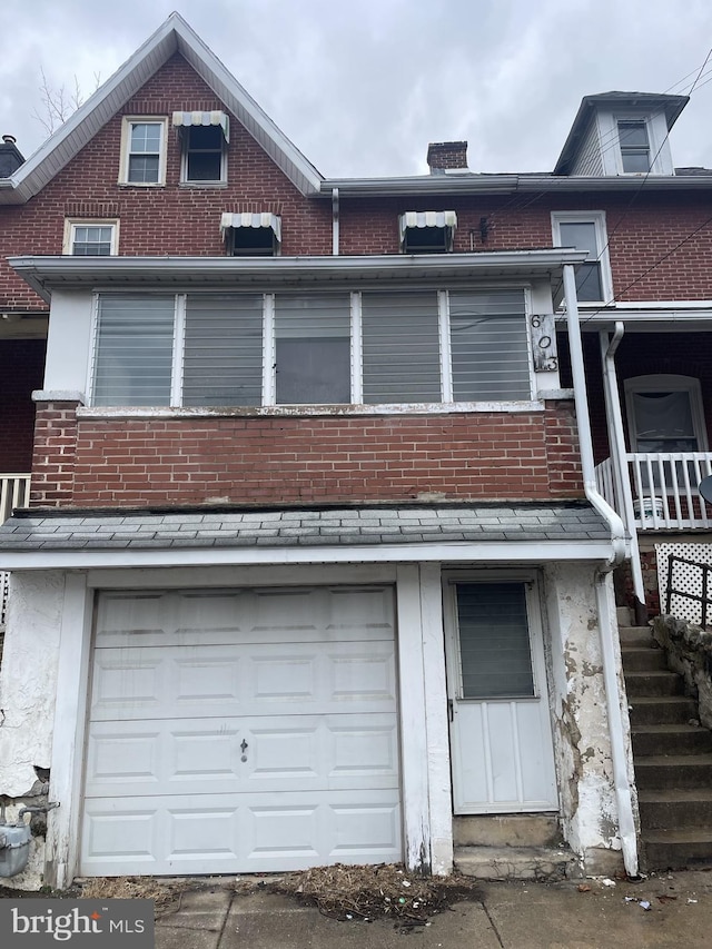 rear view of house featuring a garage