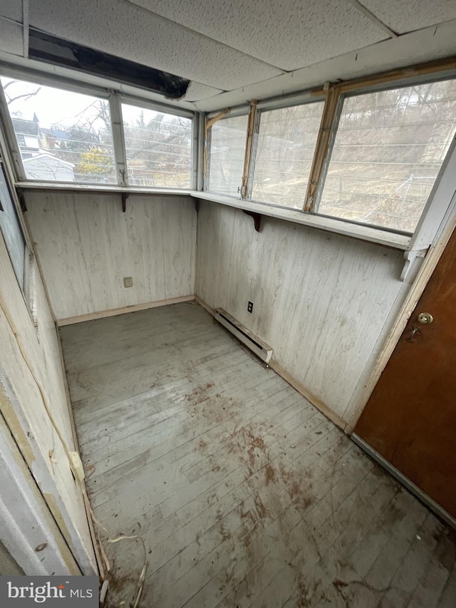 unfurnished sunroom featuring baseboard heating