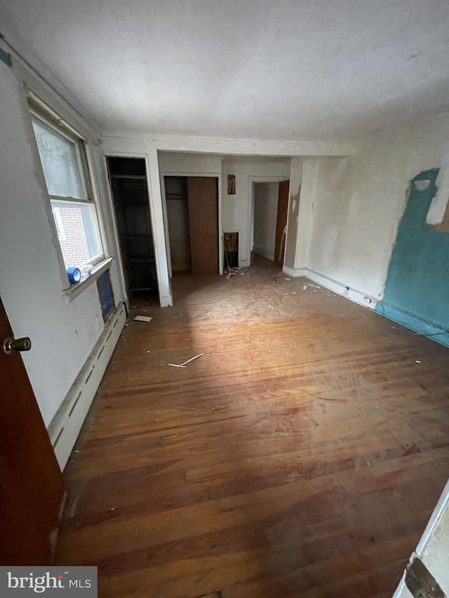 interior space with dark hardwood / wood-style flooring and baseboard heating