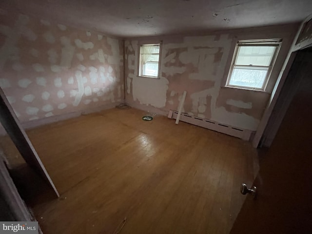 unfurnished room featuring a baseboard radiator and wood-type flooring