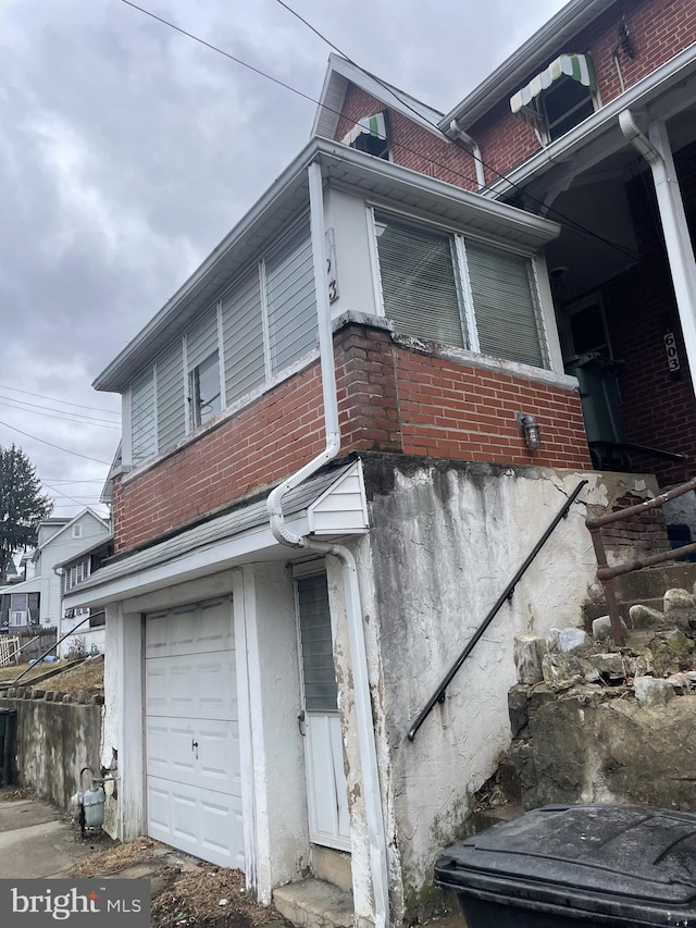 view of property exterior with central AC unit and a garage