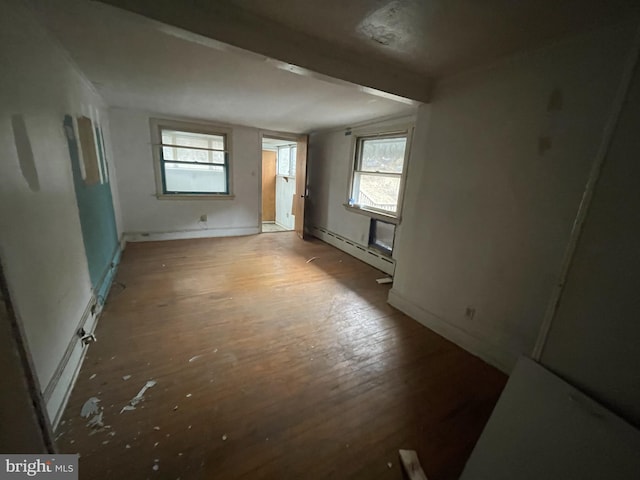 unfurnished room with a baseboard radiator and dark hardwood / wood-style floors