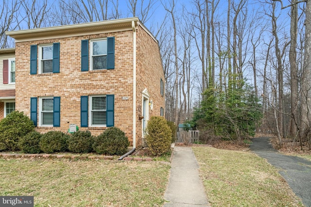 view of front of property featuring a front lawn and brick siding