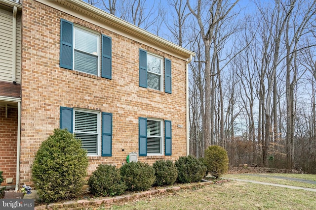 view of side of home with a yard and brick siding