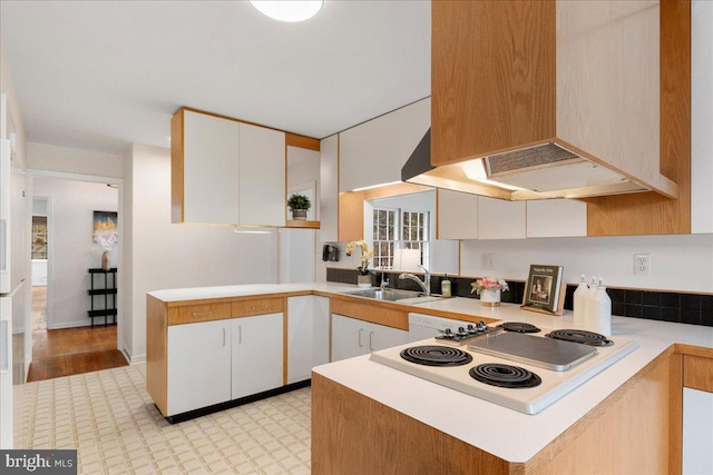 kitchen featuring white cabinetry, kitchen peninsula, and premium range hood