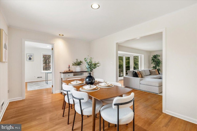 dining room with light hardwood / wood-style flooring and ornamental molding