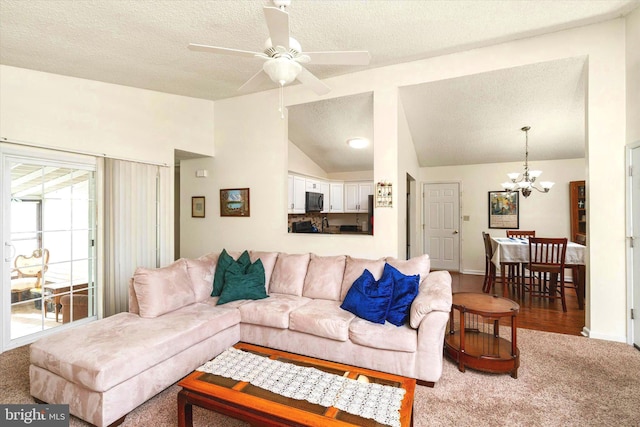 carpeted living room featuring vaulted ceiling, ceiling fan with notable chandelier, and a textured ceiling