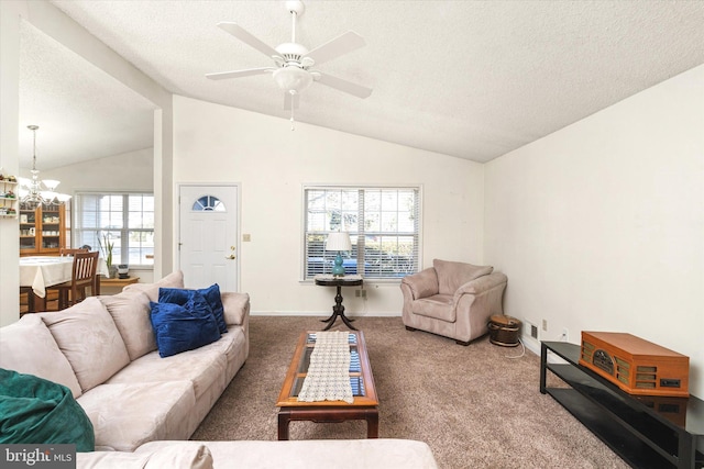 living room with ceiling fan with notable chandelier, carpet floors, a textured ceiling, and vaulted ceiling