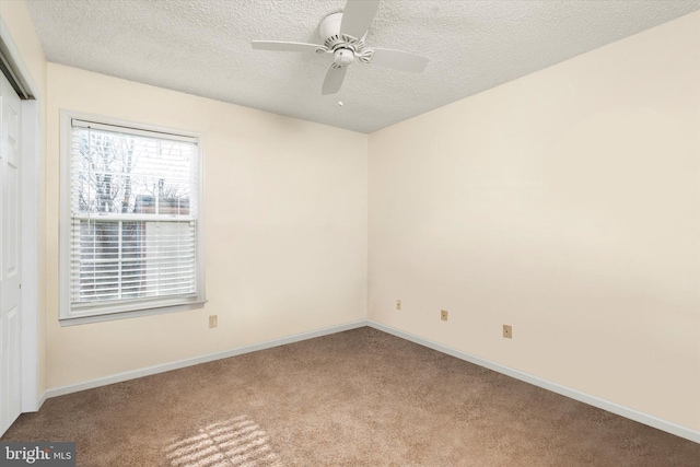 unfurnished room featuring ceiling fan, light colored carpet, and a textured ceiling