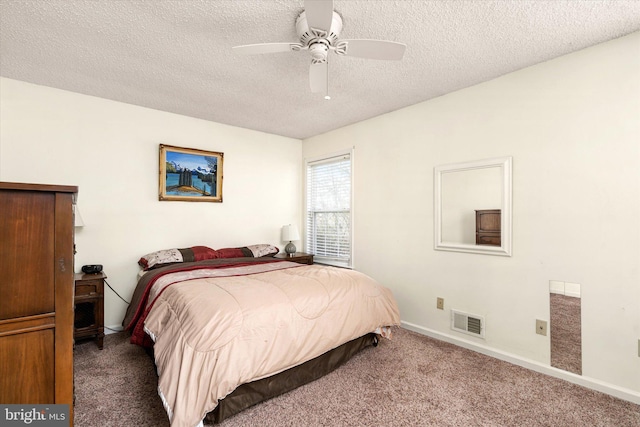 carpeted bedroom with ceiling fan and a textured ceiling