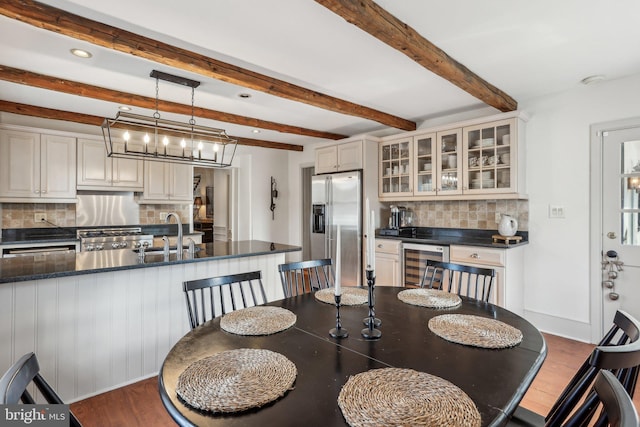 dining room with beamed ceiling, sink, beverage cooler, and dark hardwood / wood-style flooring