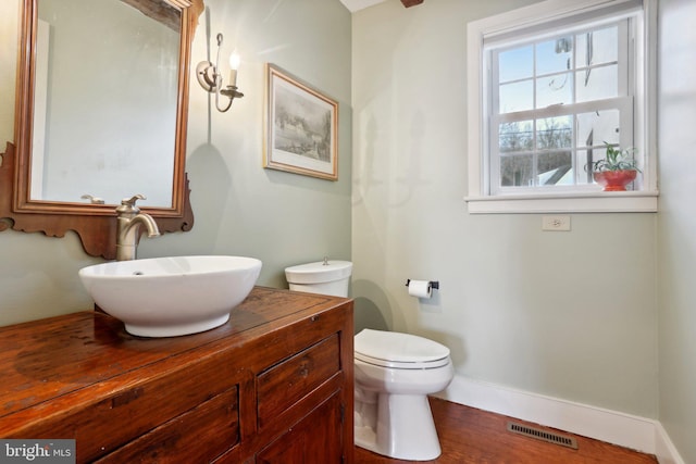 bathroom with vanity, wood-type flooring, and toilet