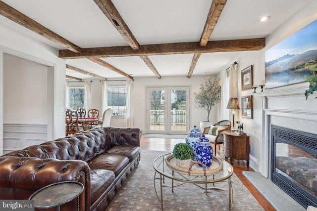 living room featuring beam ceiling, wood-type flooring, and french doors