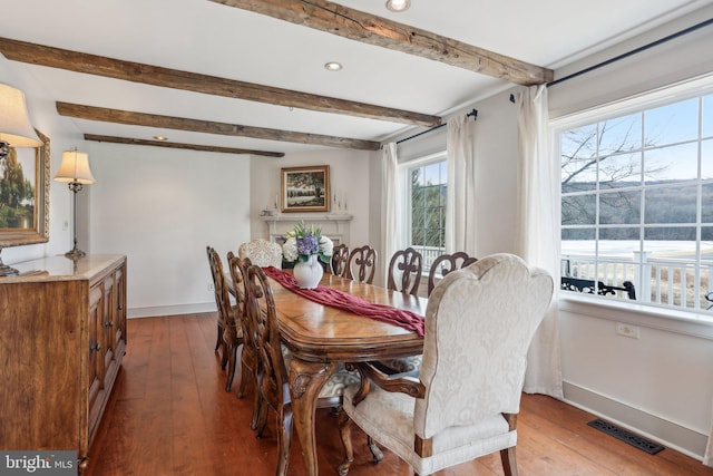 dining area featuring beamed ceiling and light hardwood / wood-style floors