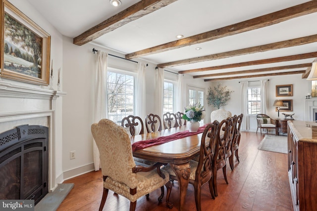 dining area featuring beamed ceiling and wood-type flooring