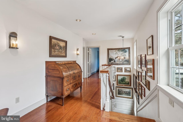 hallway featuring an inviting chandelier and hardwood / wood-style floors