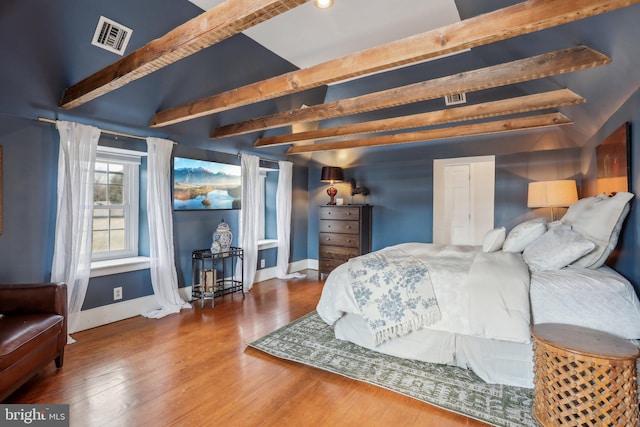 bedroom featuring beamed ceiling and hardwood / wood-style floors