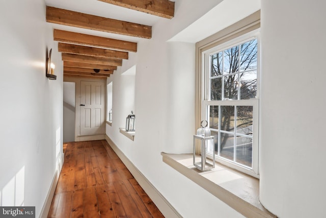 corridor with beamed ceiling and wood-type flooring