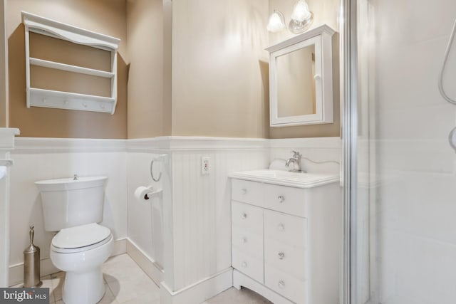 bathroom with tile patterned flooring, vanity, a shower, and toilet