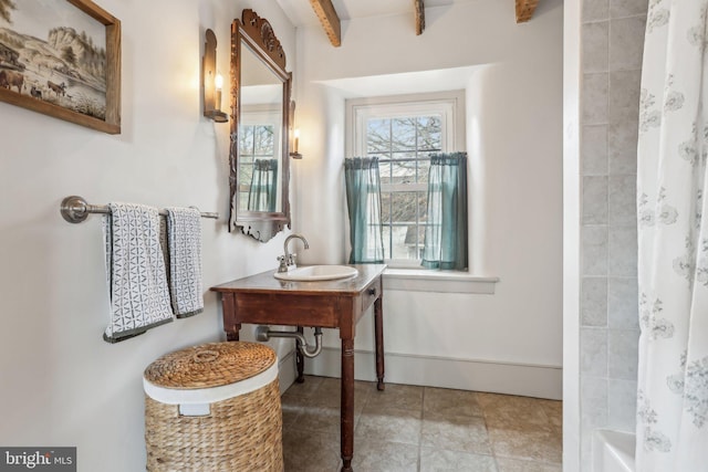 bathroom featuring shower / bath combination with curtain, tile patterned floors, and sink