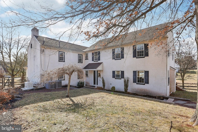 view of front of property featuring central AC unit and a front lawn