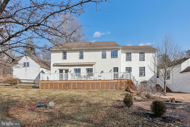 rear view of house with a lawn and a deck