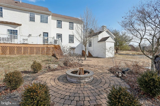 back of house featuring a wooden deck, a fire pit, and a patio area