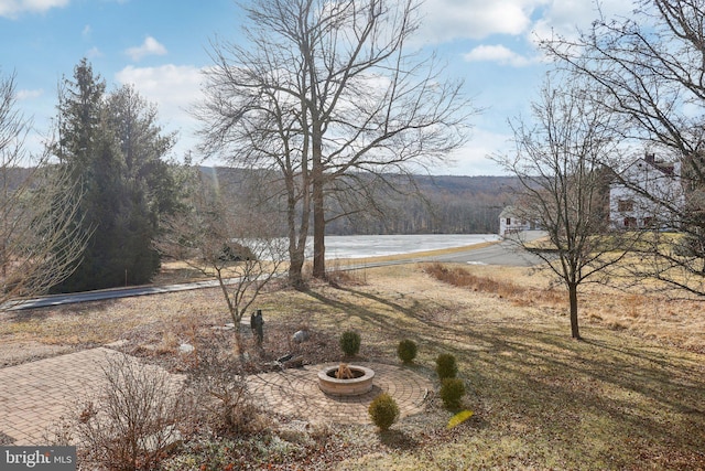 view of yard with a water view, a patio area, and a fire pit