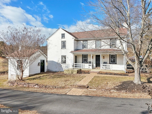 view of front of house with covered porch and a front lawn