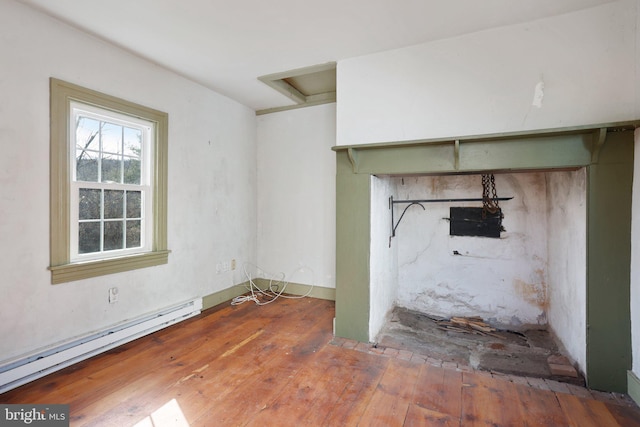 interior space with hardwood / wood-style flooring and a baseboard heating unit